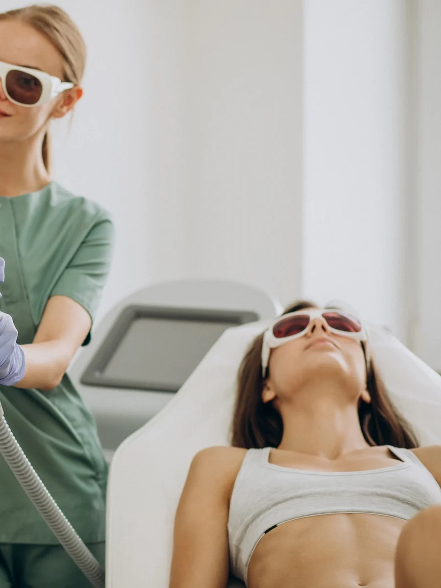 Practitioner performing a laser treatment on a client at an aesthetics clinic