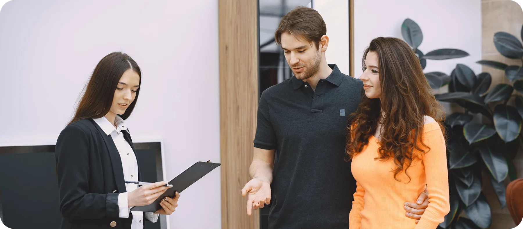 Salesperson with a clipboard helping a couple choose furniture