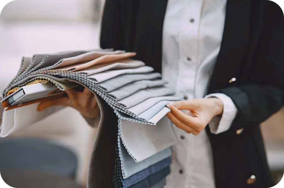 Salesperson holding a fan of upholstery fabric swatches