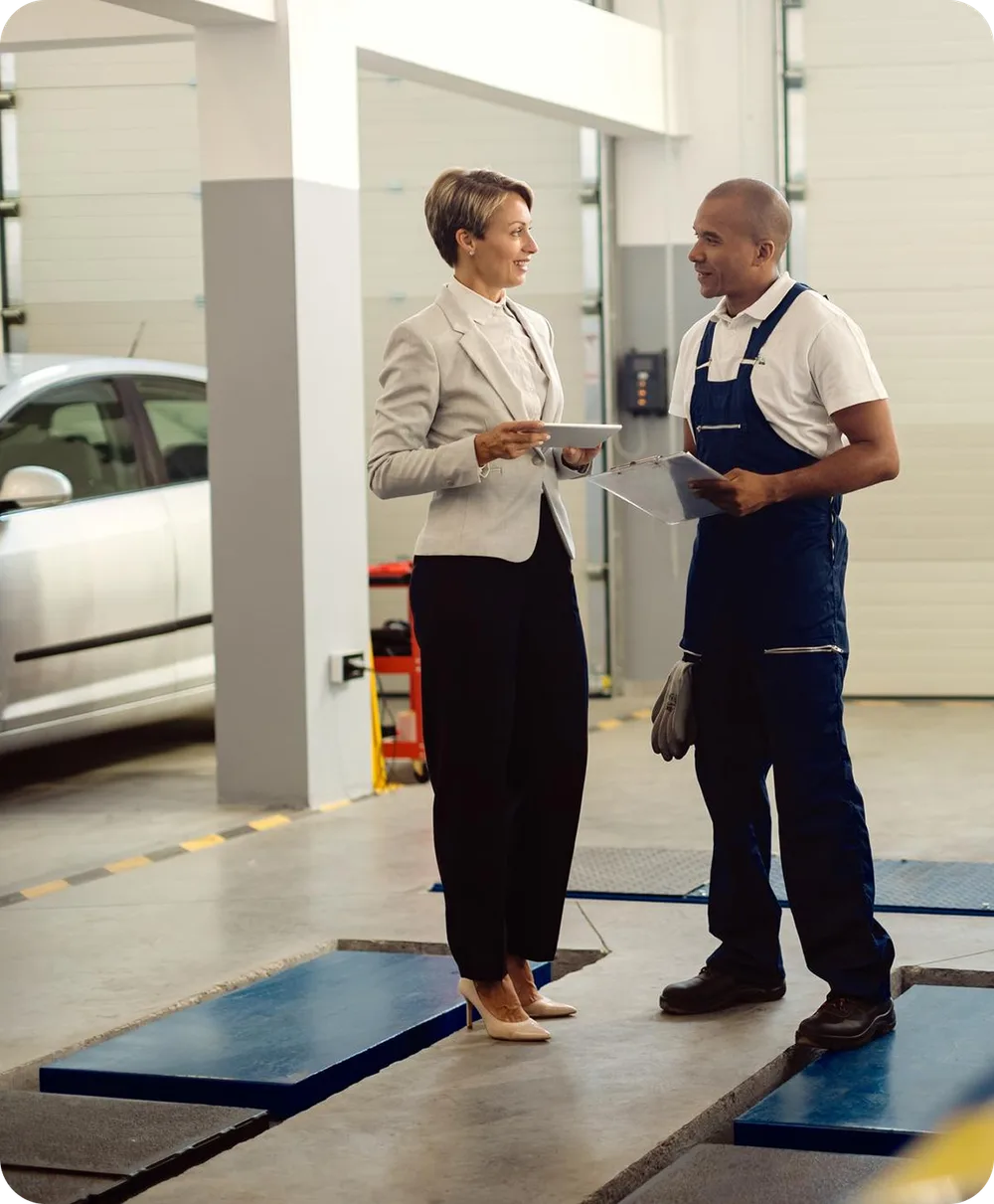 Manager with a tablet talking with a technician in a workshop